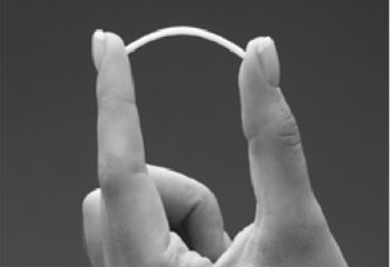 two fingers slightly bending a piece of implant